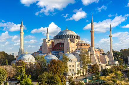 Außenansicht der Hagia Sophia in Istanbul mit Kuppeln, Minaretten und blauem Himmel voller leichter Wolken