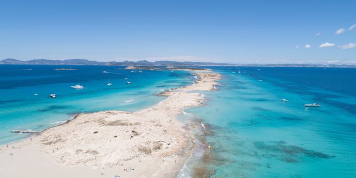 Luftaufnahme des Strandes Ses Illetes auf Formentera mit weißem Sand und türkisblauem Wasser