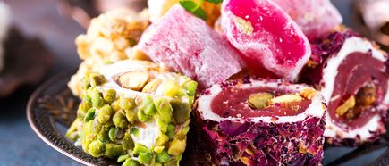 Buntes Lokum Sortiment, türkischer Honigwürfel mit Pistazien und Nussfüllung auf dekorativem Teller