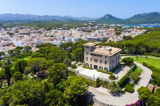 Luftaufnahme der Villa Sa Torre Cega in Cala Ratjada auf Mallorca, umgeben von Gärten, Bäumen und mit Blick auf die Stadt und das Meer