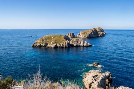 Die Malgrats-Inseln vor Mallorca, mit felsigen Küsten und grünem Bewuchs, umgeben von klarem, blauem Wasser.