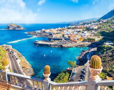 Aussicht auf die Küstenstadt Garachico auf Teneriffa mit natürlicher Lavaküstenlandschaft, türkisfarbenem Wasser, farbenfrohen Gebäuden und umliegenden Berghängen