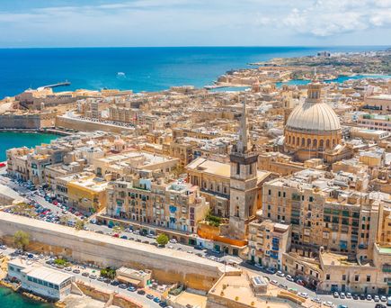 Luftaufnahme der historischen Altstadt von Valletta auf Malta mit der markanten Kuppel der St. Johns Co-Kathedrale und dem umliegenden Hafen