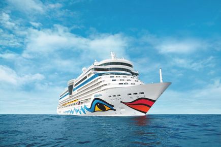 Das Kreuzfahrtschiff AIDAbella fährt über das offene Meer unter klarem blauem Himmel, mit dem charakteristischen AIDA‑Bugdesign und mehreren Außendecks