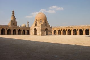 Innenhof der ägyptischen Ibn-Tulun-Moschee in Kairo mit zentralem Brunnen und Minarett im Hintergrund
