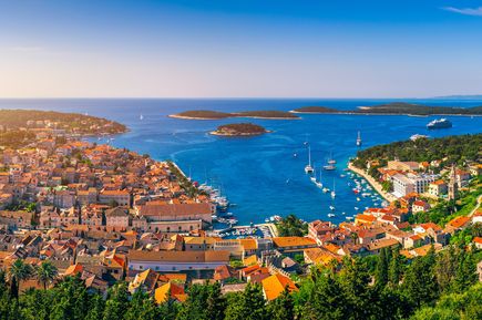 Luftaufnahme vom Hafen von Hvar in Mitteldalmatien, Kroatien, mit Altstadt, roten Dächern, Yachten und dalmatinischen Inseln im Adriatischen Meer