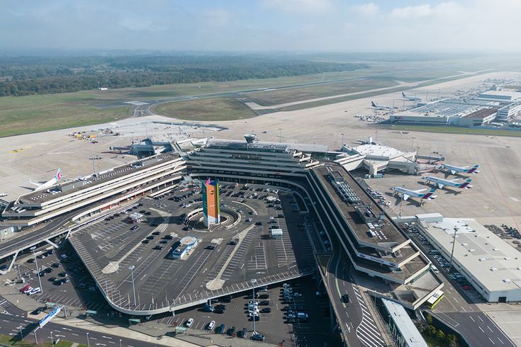 Luftaufnahme des Flughafens Köln/Bonn mit Terminalgebäuden, Vorfeld, Start- und Landebahnen sowie mehreren Passagierflugzeugen an den Gates