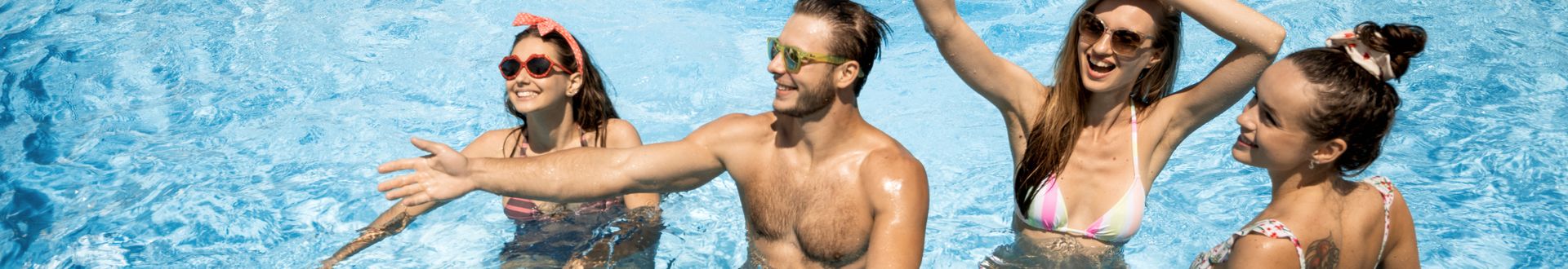 Mehrere Personen stehen in einem Swimmingpool und genießen gemeinsam die Zeit im Wasser unter sonnigem Himmel