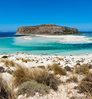 Blick auf die Lagune von Balos auf Kreta mit türkisfarbenem Wasser, Sandstrand und felsigen Inseln im Hintergrund
