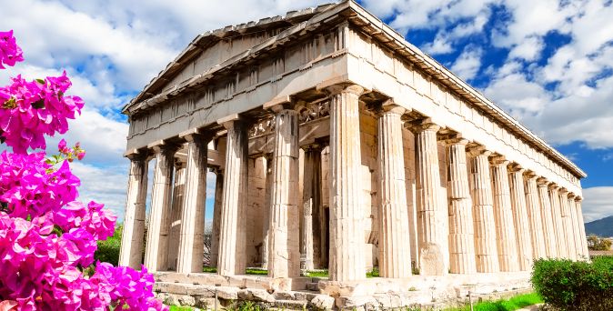 Antiker dorischer Tempel in der Athener Agora mit Säulen und Giebeldach, blühender pinker Oleander im Vordergrund.