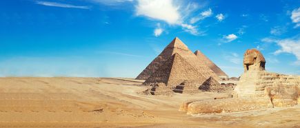 Die Pyramiden von Gizeh und die Sphinx unter einem blauen Himmel in der Wüste bei Kairo