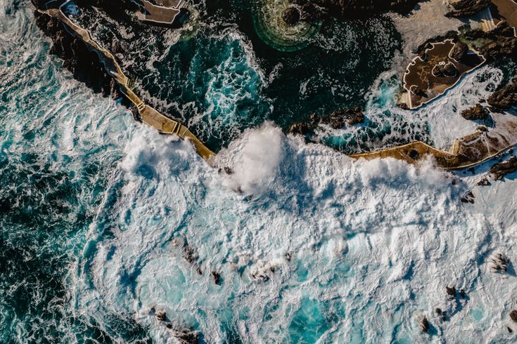 Luftaufnahme der Naturschwimmbecken von Porto Moniz auf Madeira mit Brandung, vulkanischen Felsen und Meerwasserpools an der Küste