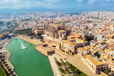 Luftaufnahme von Palma de Mallorca mit der Kathedrale La Seu im Zentrum, umgeben von der Altstadt und einem Wasserbecken mit Springbrunnen im Vordergrund