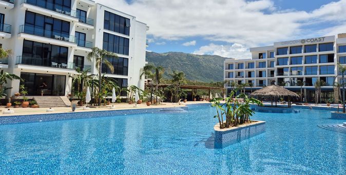 Weitläufige Poollandschaft des Oricon Coast Luxury Resorts mit tropischer Bepflanzung, modernen Hotelgebäuden und grüner Bergkulisse im Hintergrund