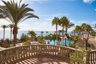 Ausblick über die weitläufige Poollandschaft des R2 Rio Calma Hotel & Spa mit Palmen, Sonnenterrassen und Blick auf das Meer.