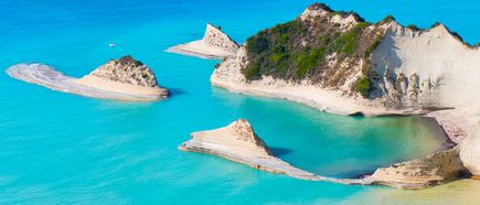 Luftaufnahme von Kap Drastis auf Korfu von mehreren kleinen, felsigen Inseln mit Vegetation in türkisfarbenem Wasser