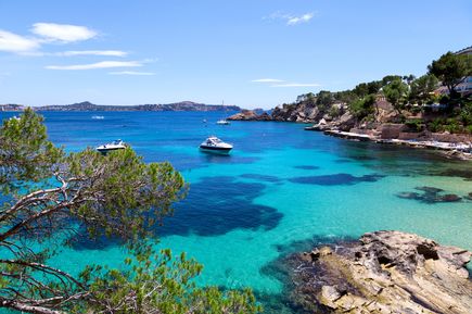 Kleine Bucht Cala Fornells auf Mallorca mit Booten, Felsen und türkisblauem Wasser
