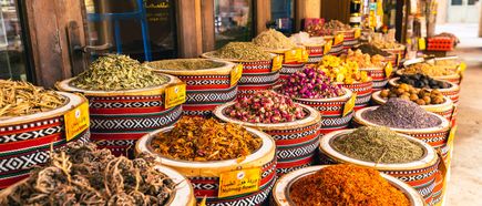 Verschiedene Gewürze und getrocknete Kräuter in runden, dekorativen Schalen auf einem Marktstand