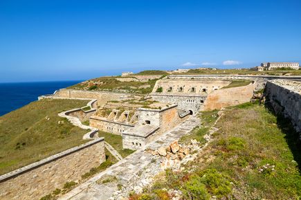 Die Festung La Mola auf Menorca liegt auf einer Anhöhe am Meer und beeindruckt mit mächtigen Steinmauern und alten Verteidigungsanlagen