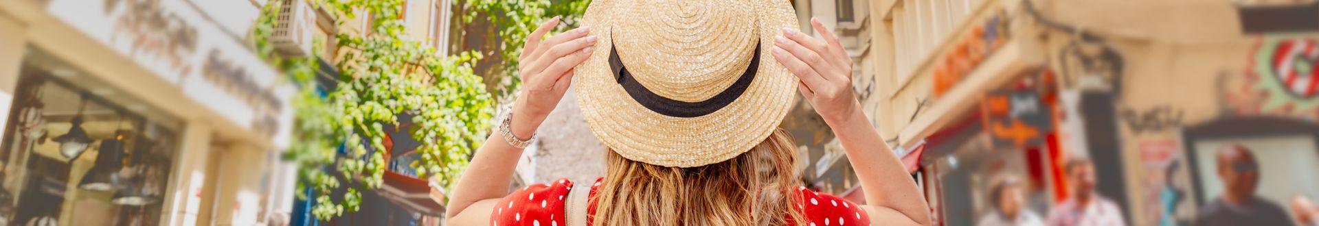 Frau mit Strohhut in der Altstadt von Istanbul vor dem Galata-Turm, umgeben von historischen Gebäuden