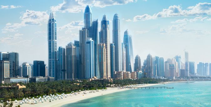 Skyline von Dubai mit hohen Wolkenkratzern am Meer unter blauem Himmel