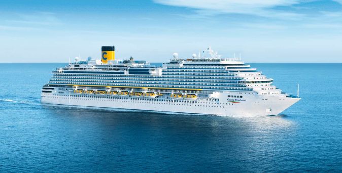 Das Kreuzfahrtschiff Costa Diadema fährt über das offene Meer bei blauem Himmel, mit mehreren Decks, Rettungsbooten und dem typischen gelben Costa-Schornstein