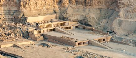 Der Totentempel der Hatschepsut in der Felswand, mit mehreren Terrassen und Säulengängen, umgeben von Wüstenlandschaft