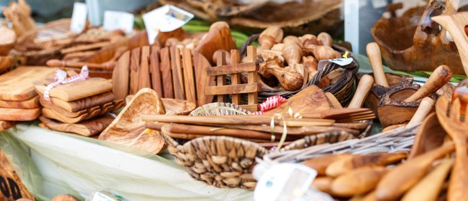 Marktstand mit verschiedenen handgefertigten Holzartikeln wie Löffeln, Schalen und Figuren