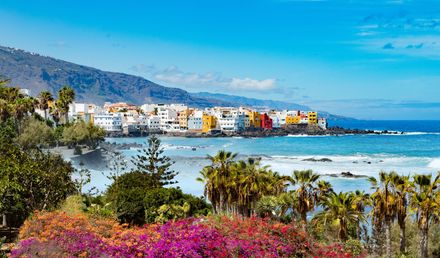 Puerto de la Cruz auf Teneriffa mit bunten Häusern an der Küste, Palmen und Atlantikblick