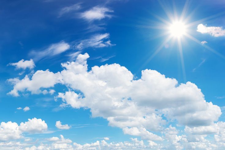 Strahlende Sonne über einem blauen Himmel mit weißen Quellwolken und einzelnen Schleierwolken