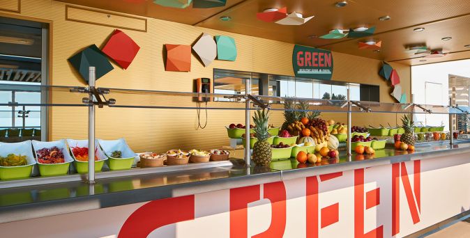 Buffetbereich ‚Green Healthy Food‘ auf der Costa Toscana mit frischem Obst, Salaten und bunten Deko-Elementen in moderner Open-Air-Atmosphäre