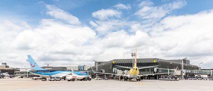 Außenansicht von Terminal C am Flughafen Hannover mit mehreren geparkten Passagierflugzeugen auf dem Vorfeld unter bewölktem Himmel