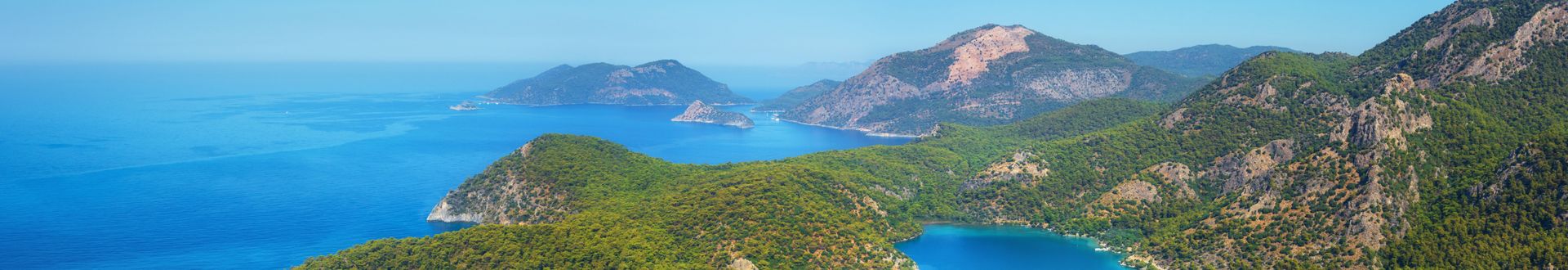 Panoramablick auf Ölüdeniz in der Türkei mit türkisblauem Meer, grünen Bergen und vorgelagerten Inseln unter klarem Himmel