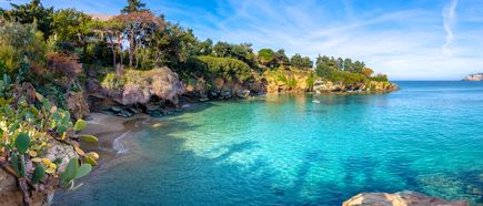 Kleine Bucht mit klarem, türkisfarbenem Wasser und felsigem Ufer, umgeben von mediterraner Vegetation auf Kreta, Griechenland