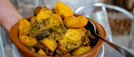 Typisches Gericht Sofrit Pagès aus Ibiza mit Fleisch, Kartoffeln und Gewürzen in einer Terrakottaschale serviert