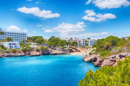 Bucht Cala Esmeralda bei Cala d’Or mit glasklarem Wasser, Sandstrand und Hotels im Hintergrund