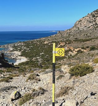 Blick auf bewaldete Hügel und Berge mit einem Inselberg im Meer unter blauem Himmel.