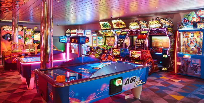 Die Arcade-Spielhalle auf der Costa Toscana mit Airhockey-Tischen, Rennspiel-Automaten und farbenfroher Beleuchtung