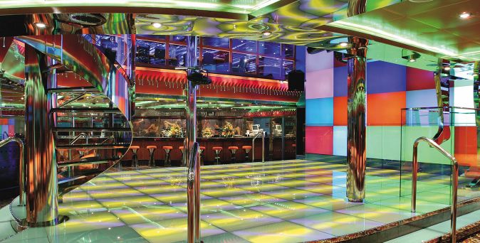 Die Disco Vulcania 1927 auf der Costa Fortuna mit spiraliger Treppe, bunter Lichtinstallation, Barbereich und glitzernder Tanzfläche