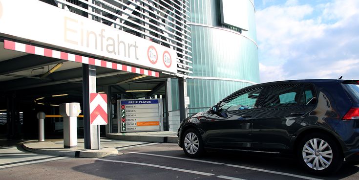 Einfahrtsbereich von Parkhaus 1 am Flughafen Hannover mit beschilderter Parkplatzanzeige und einem Pkw vor der Schranke.