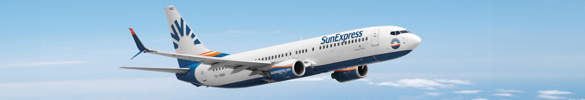 SunExpress Boeing 737-800 im Flug vor blauem Himmel mit sichtbarem SunExpress-Logo auf Rumpf und Leitwerk