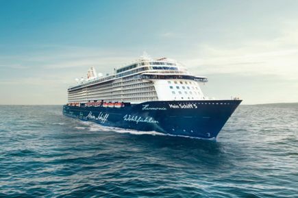 Das Kreuzfahrtschiff Mein Schiff 5 fährt bei klarem Himmel über das offene Meer und ist seitlich von vorn zu sehen.