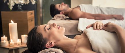 „Paar genießt eine entspannende Massage bei Kerzenschein im Wellnessbereich