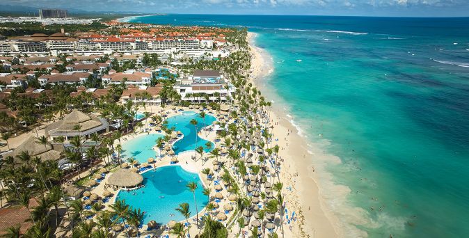 Luftaufnahme des Bahia Principe Grand Punta Cana mit weitläufigem Poolbereich, Palmen und langem Sandstrand am türkisfarbenen Meer