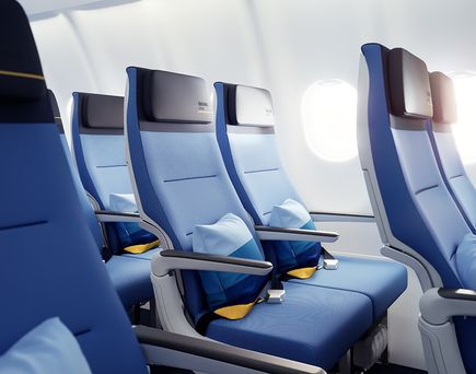 Blue Ocean Economy-Class-Sitze von Discover Airlines mit Kopfstützen und Kissen in einer Flugzeugkabine vor mehreren Fenstern