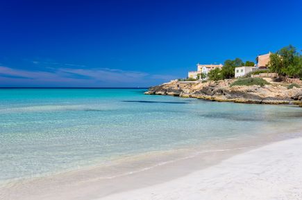 Karibisch anmutender Strand Es Trenc auf Mallorca mit weißem Sand, flachem türkisfarbenem Meer und weitem Horizont