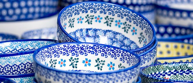 Mehrere ineinander gestapelte Keramikschalen mit blau-weißen und gelb-blauen floralen Mustern.