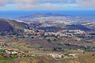 noramablick auf Las Palmas de Gran Canaria mit weitläufigem Stadtgebiet, Wohnvierteln in hügeliger Landschaft, Hafenanlagen und dem Atlantik im Hintergrund