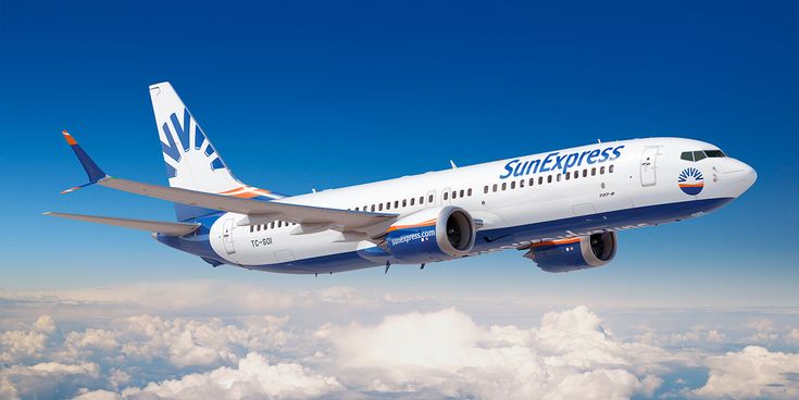 SunExpress Boeing 737-8 im Flug über den Wolken mit sichtbarem SunExpress-Logo vor klarem blauem Himmel