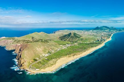 Luftaufnahme der Insel Porto Santo in Portugal mit langem Sandstrand, türkisblauem Atlantik, grünen Hügellandschaften und Küstenorten entlang der Küste